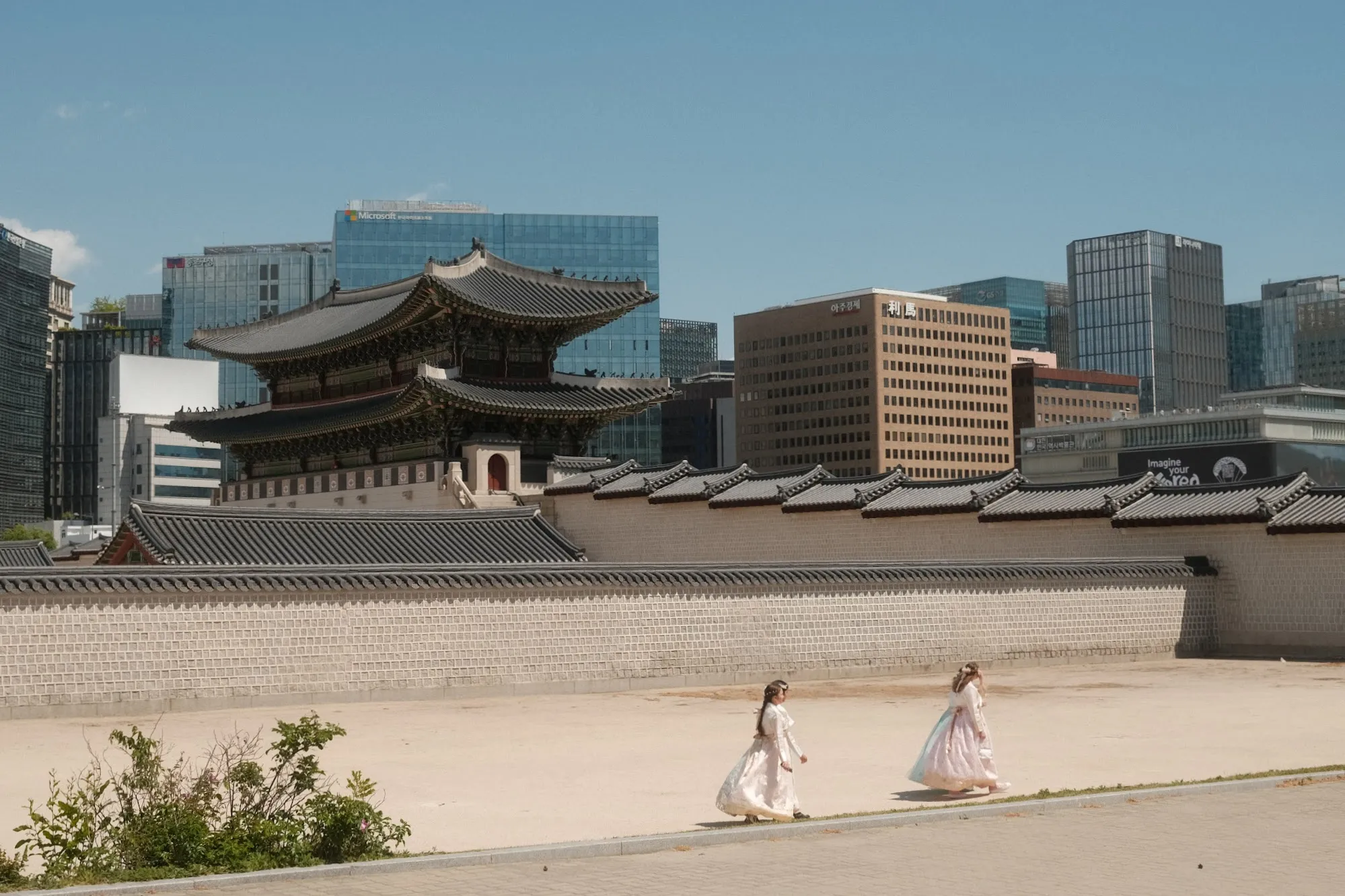 Visitors in hanbok crossing a palace courtyard