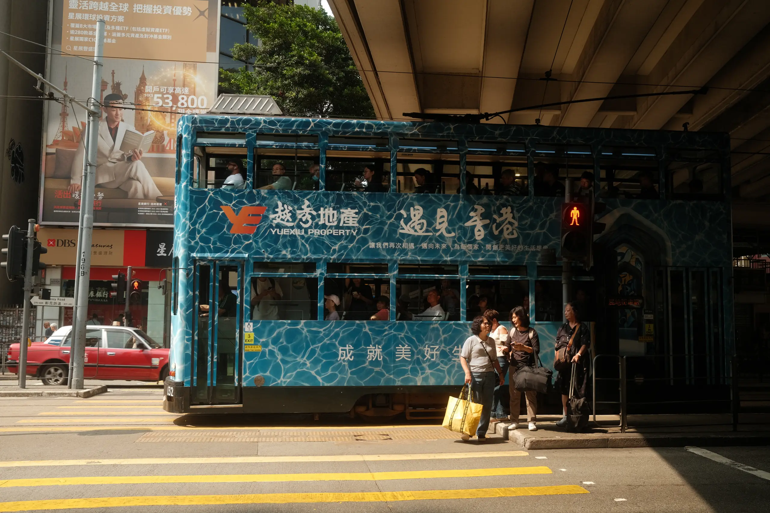 A blue double-decker tram at a junction