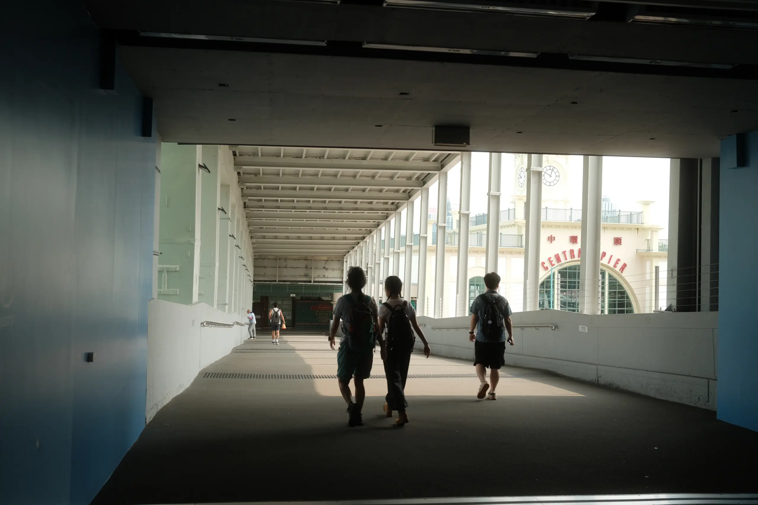 Silhouettes in a covered walkway by the harbour