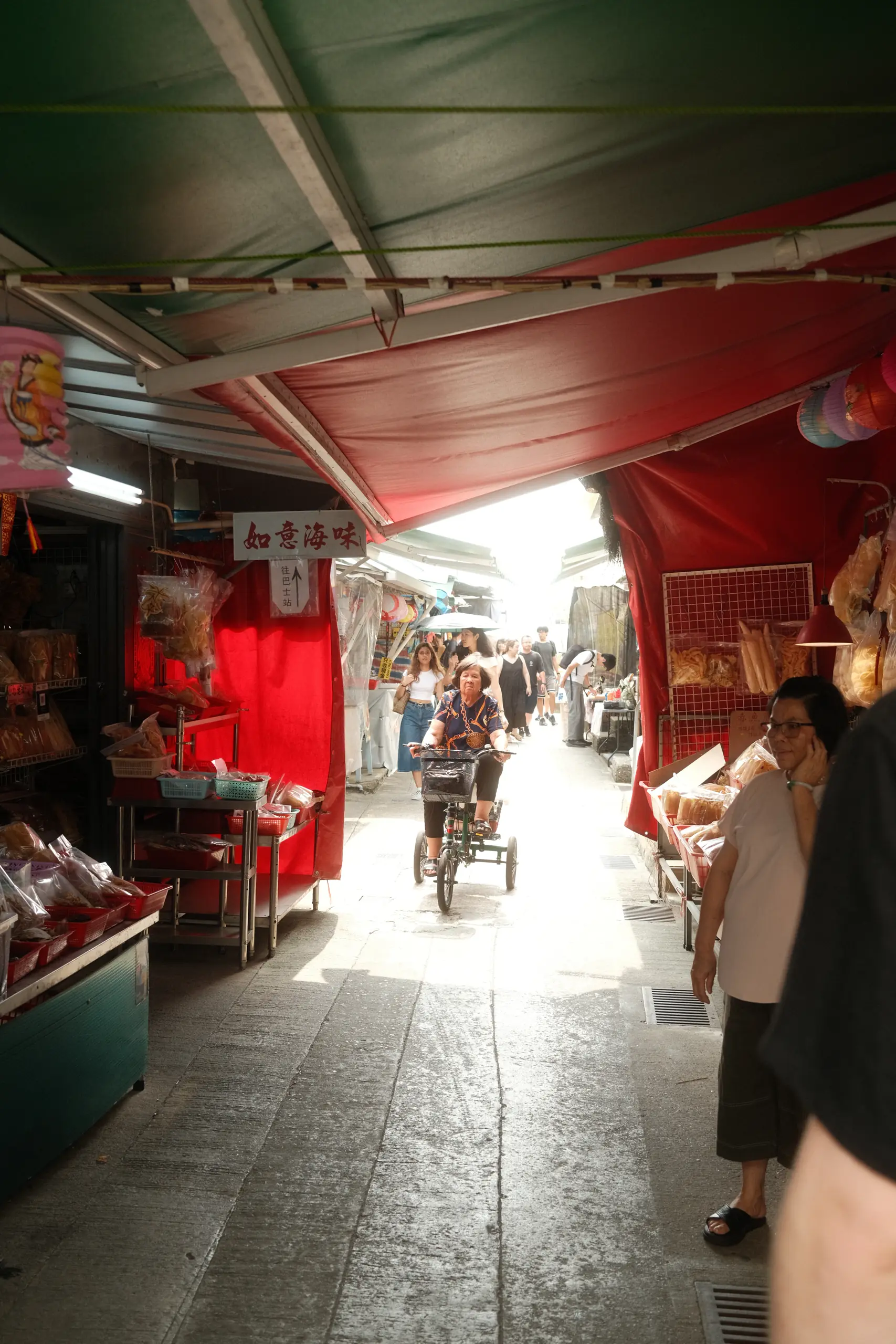 A covered market lane in Tai O with red awnings