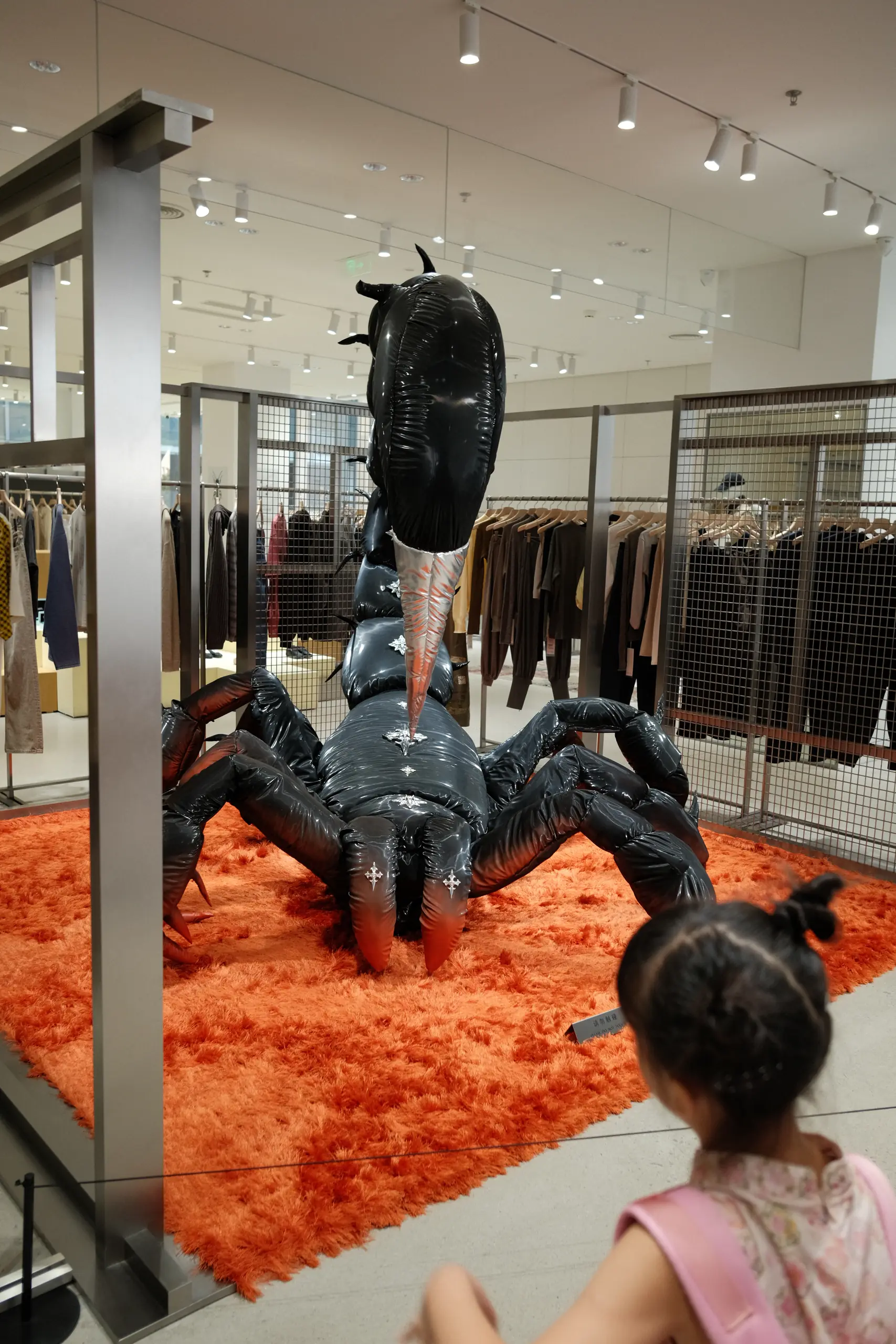 A giant scorpion sculpture on an orange carpet in a store