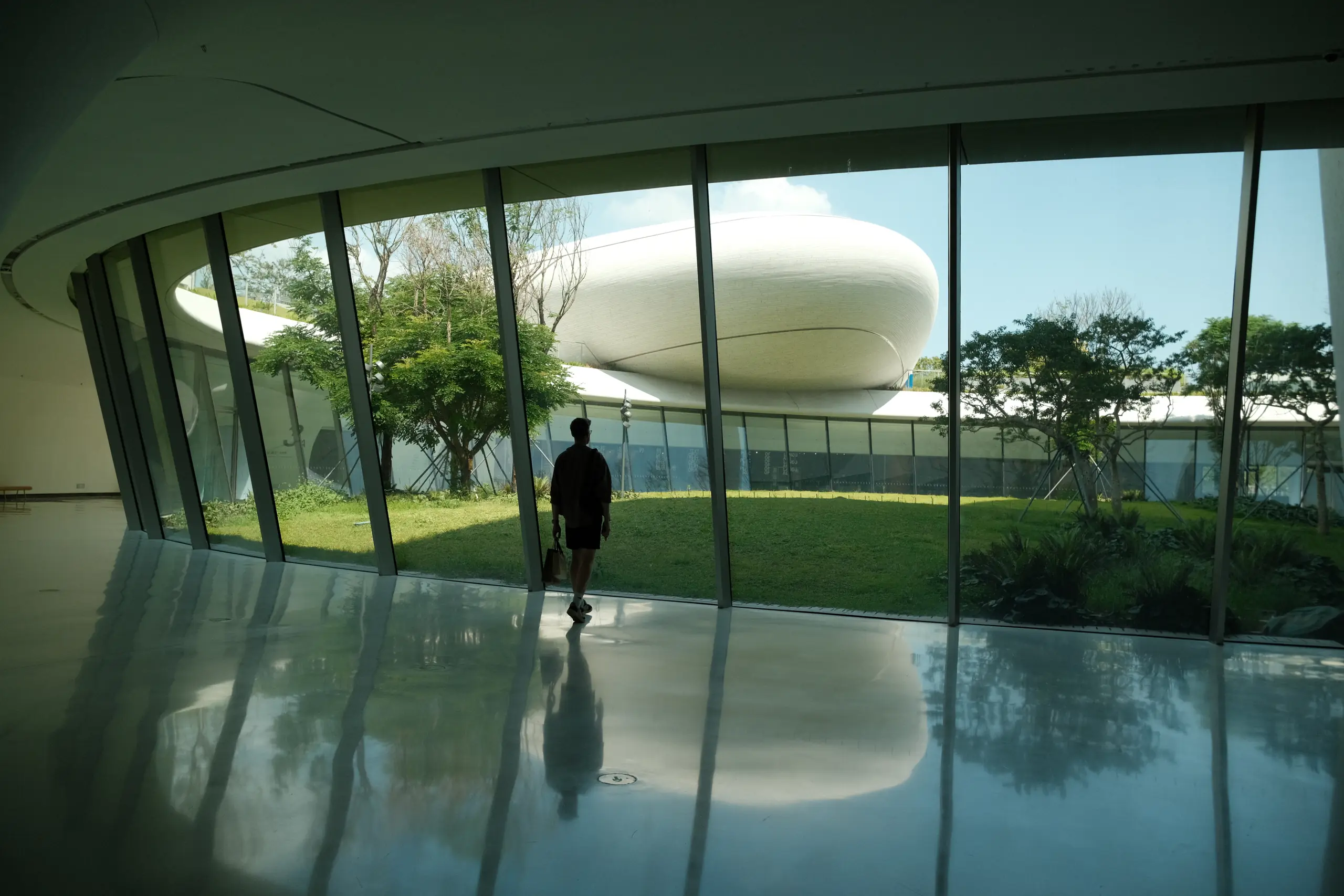 A silhouette in front of a white cloud-shaped museum building