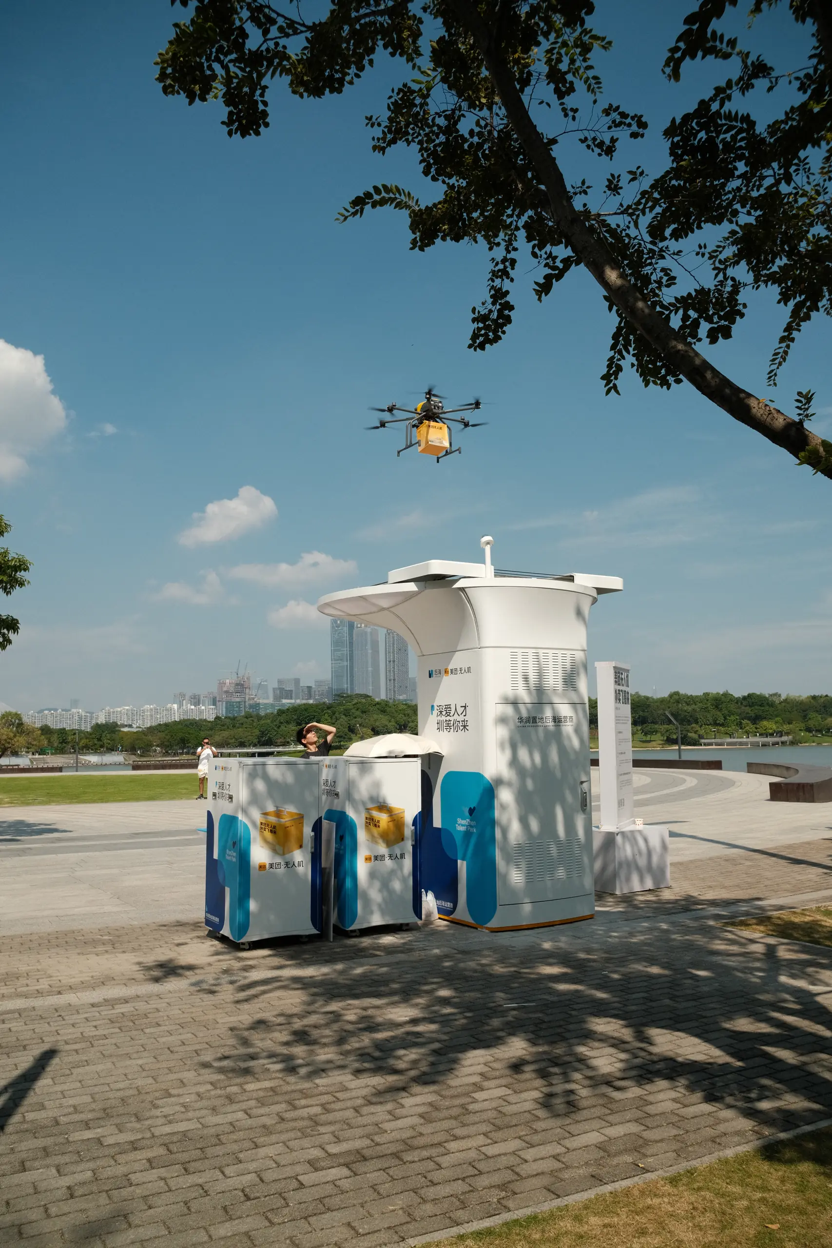 A drone hovering above a delivery station in a park