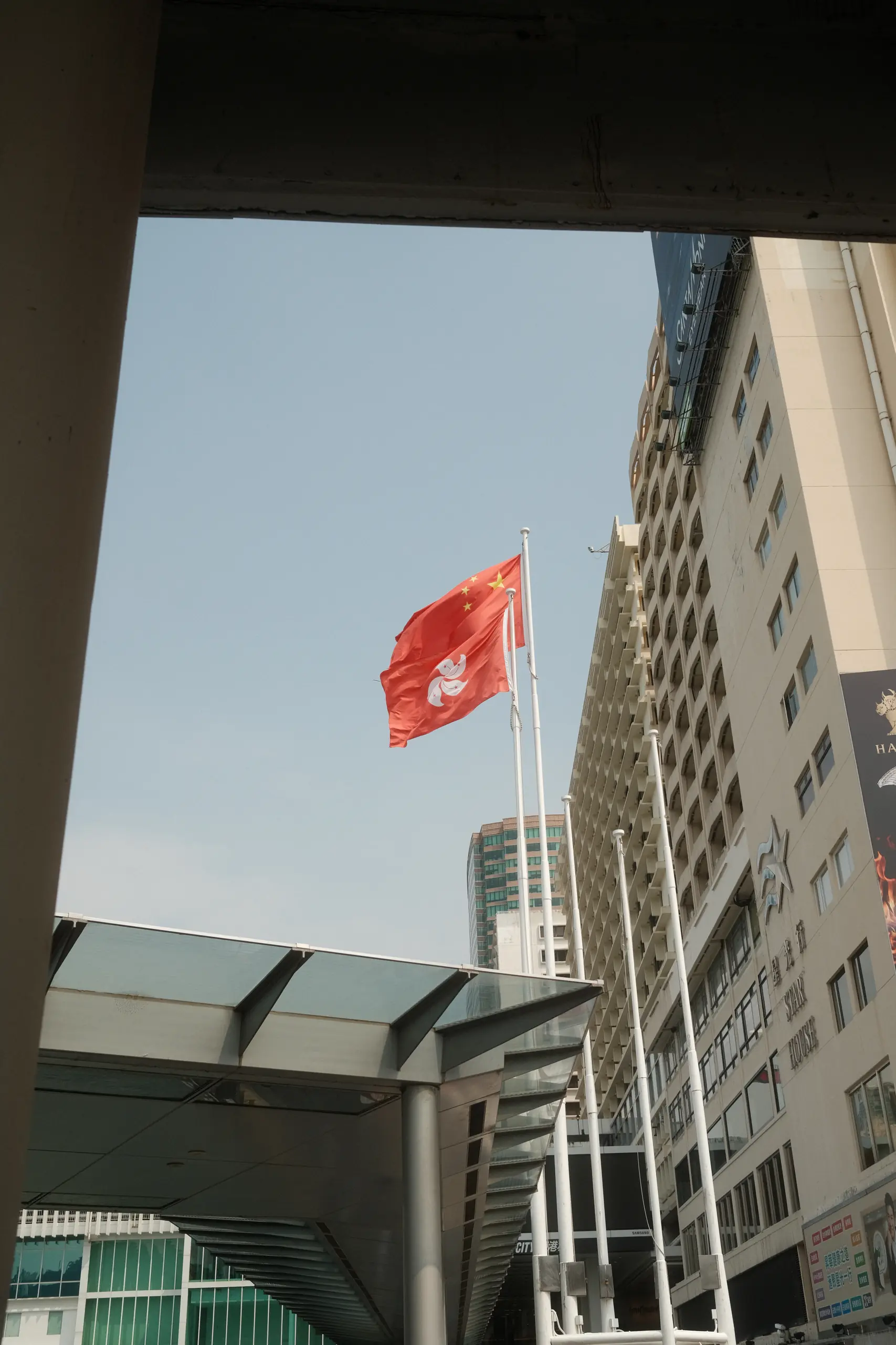 The Hong Kong flag flying between high-rises