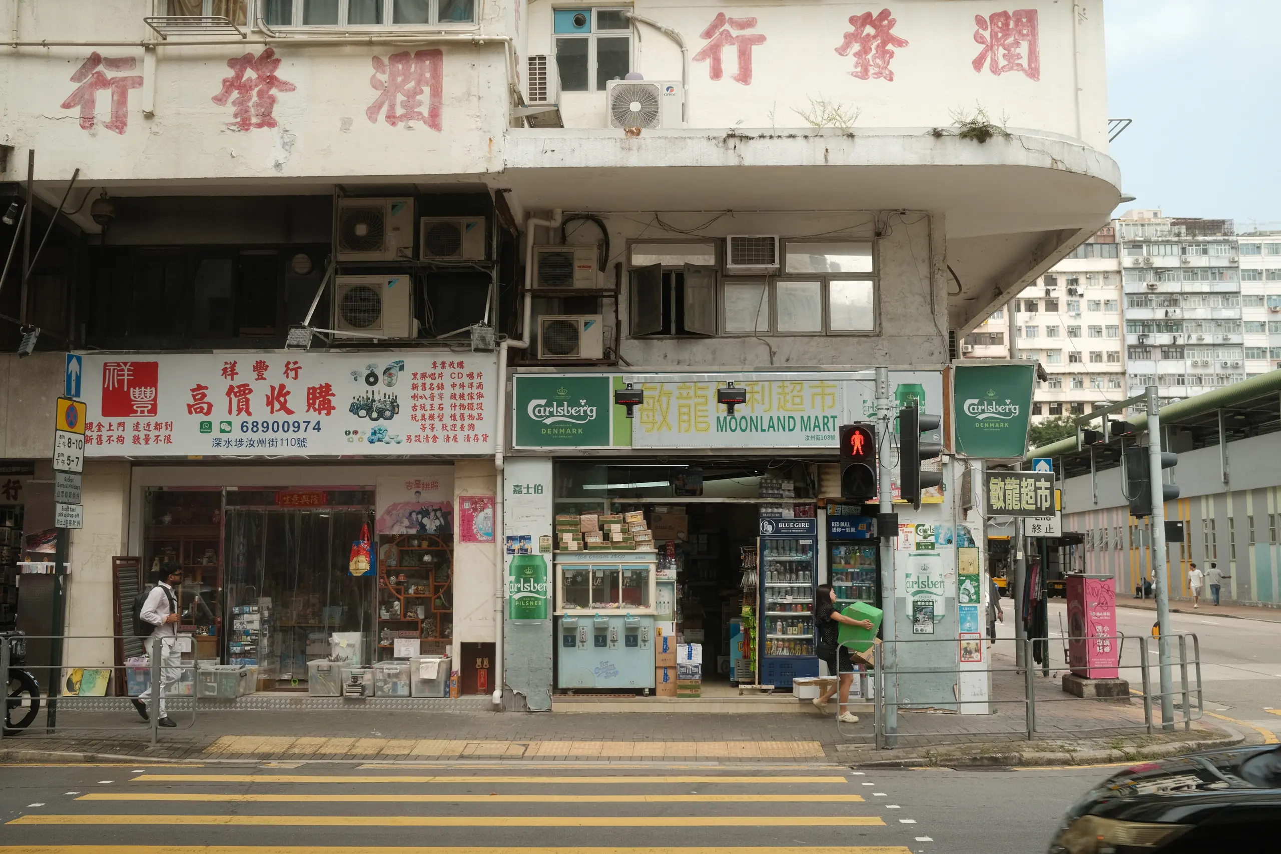 Hand-painted shop signs stacked on a street corner