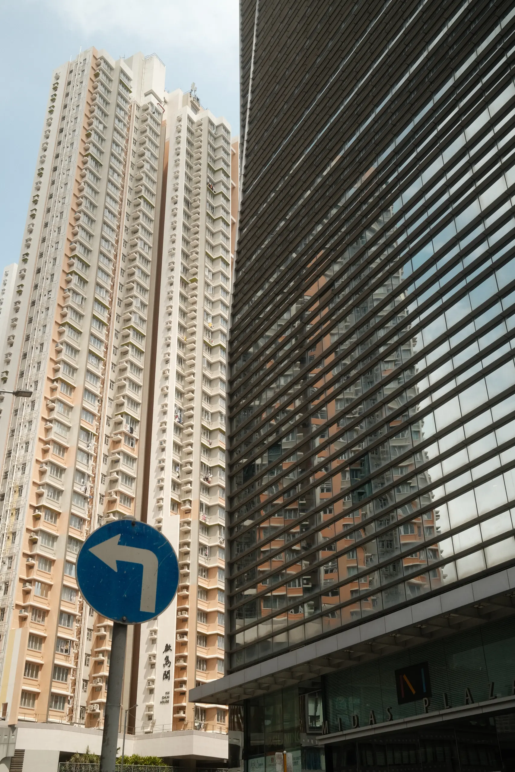 A housing tower behind a blue road sign